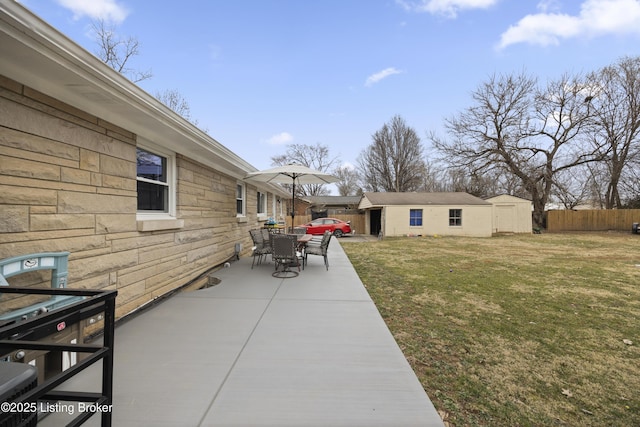 view of yard with a patio area, fence, and an outbuilding