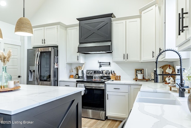 kitchen featuring hanging light fixtures, wall chimney range hood, appliances with stainless steel finishes, and white cabinets