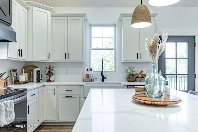 kitchen featuring white cabinetry, pendant lighting, and a sink