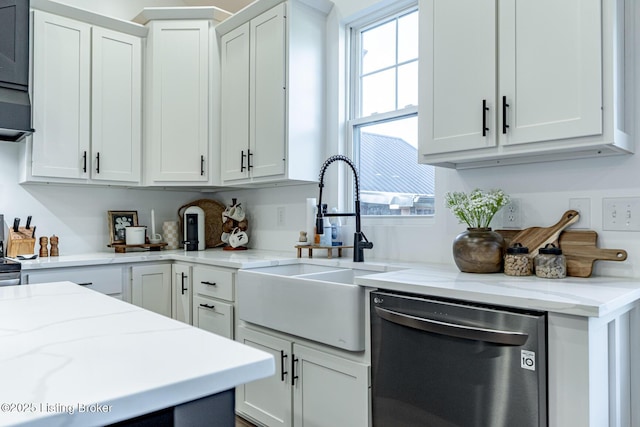 kitchen with white cabinetry, a sink, stainless steel dishwasher, and light stone countertops