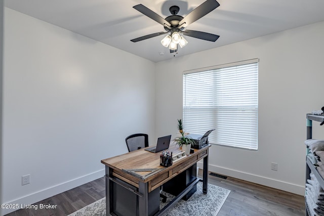 office space with dark wood-type flooring, visible vents, baseboards, and a ceiling fan