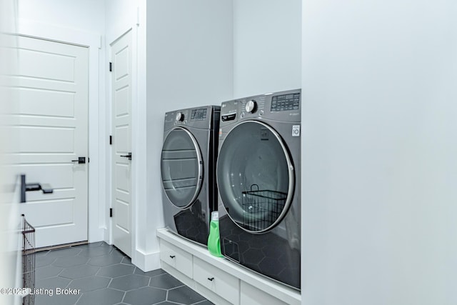 laundry room featuring laundry area, washer and dryer, and dark tile patterned flooring