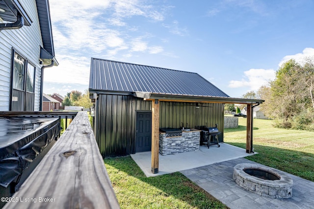 view of patio featuring a grill, a fire pit, and an outdoor kitchen