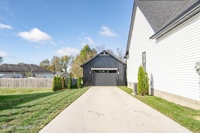 view of side of home with a garage, a lawn, fence, an outdoor structure, and board and batten siding