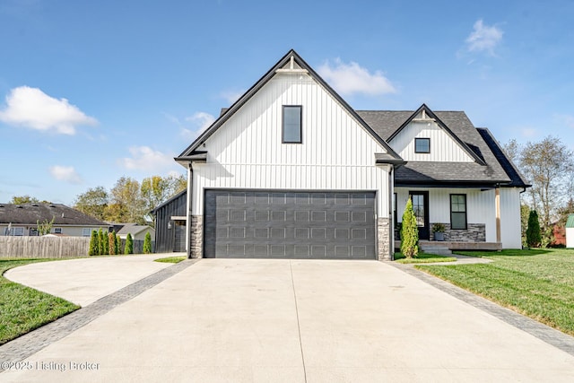 modern farmhouse style home featuring a garage, stone siding, a front lawn, and concrete driveway