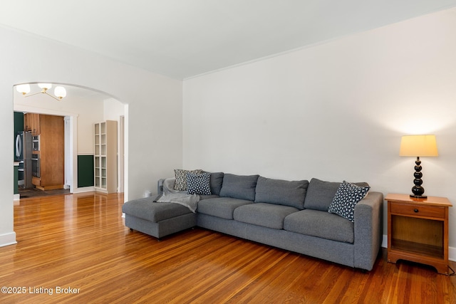 living room with light wood-type flooring and arched walkways