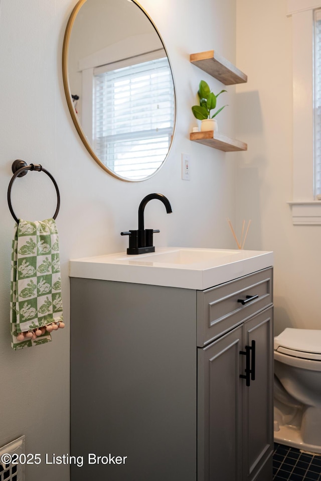 half bath featuring vanity and toilet