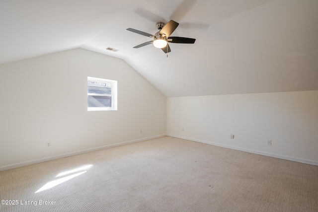 additional living space with lofted ceiling, visible vents, light carpet, and baseboards