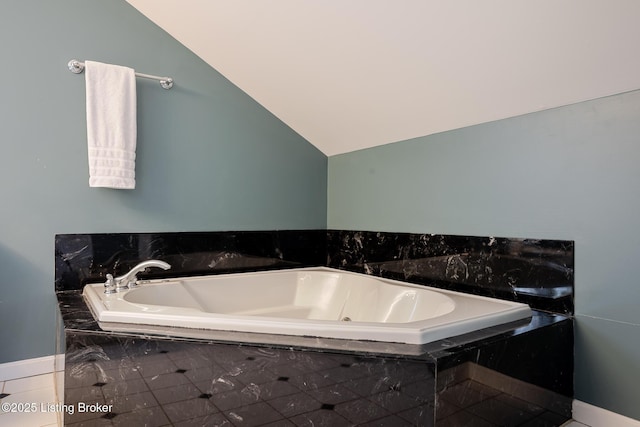 bathroom with lofted ceiling and a garden tub