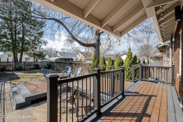 wooden deck with a fenced backyard