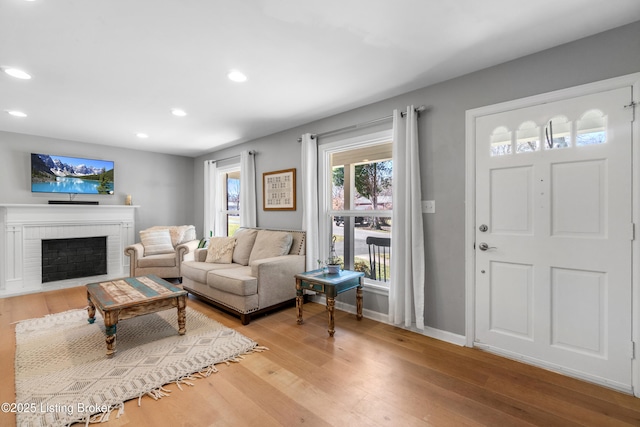 living room with recessed lighting, a fireplace, wood finished floors, and baseboards