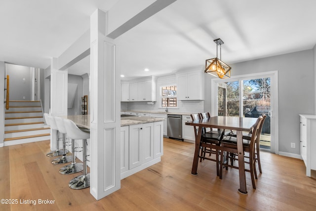 dining area with light wood-style floors, stairs, baseboards, and recessed lighting