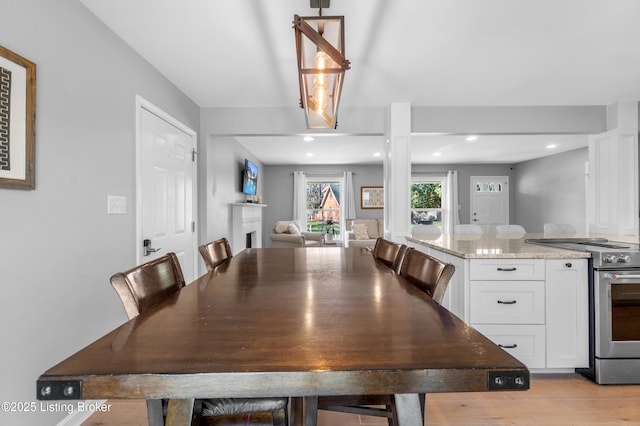 dining room with recessed lighting and a fireplace