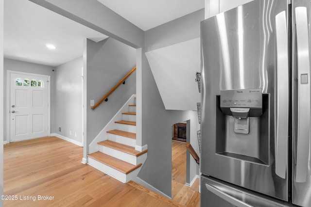 entrance foyer featuring light wood-type flooring, stairway, and baseboards