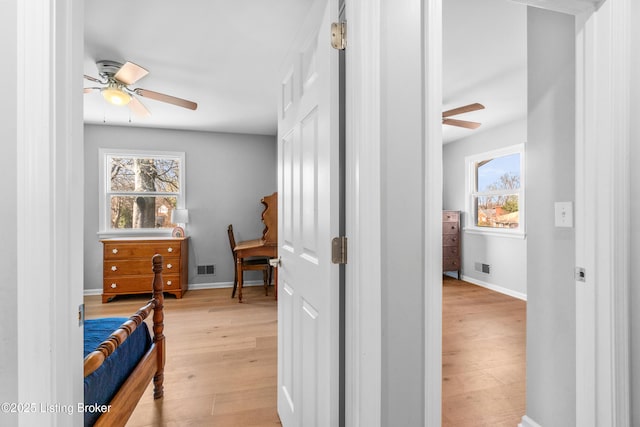 interior space featuring light wood-style floors, visible vents, and baseboards