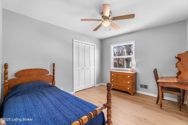 bedroom with baseboards, visible vents, a ceiling fan, light wood-style flooring, and a closet