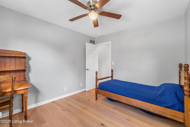 bedroom featuring light wood-style floors, visible vents, baseboards, and a ceiling fan