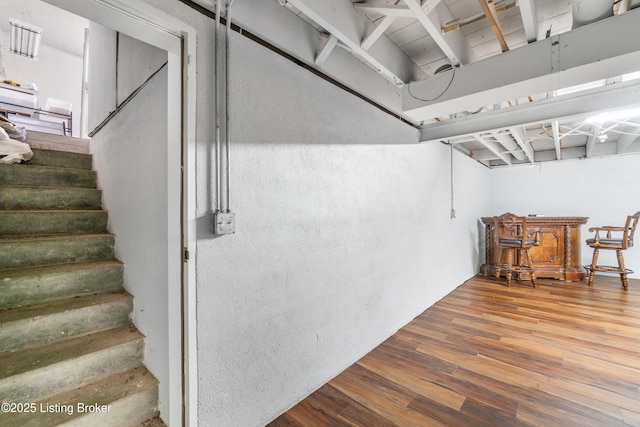 basement featuring stairway and wood finished floors