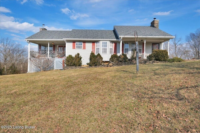 ranch-style house with a porch, roof with shingles, a chimney, and a front lawn