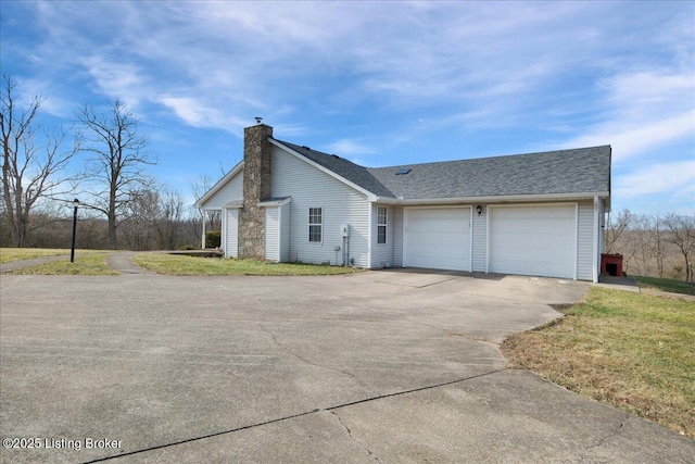 view of front of house featuring a shingled roof, concrete driveway, a chimney, and an attached garage