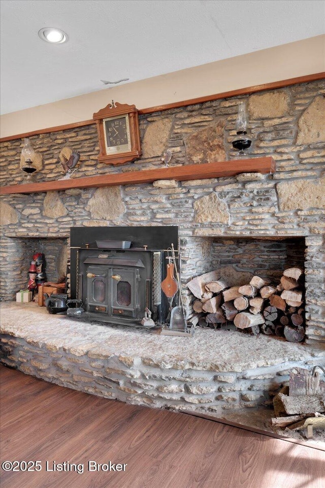 interior details with a wood stove and wood finished floors