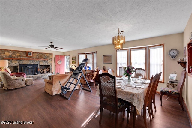 dining space featuring a textured ceiling, ceiling fan with notable chandelier, and dark wood finished floors