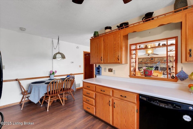 kitchen with black dishwasher, brown cabinetry, dark wood-style floors, light countertops, and a textured ceiling