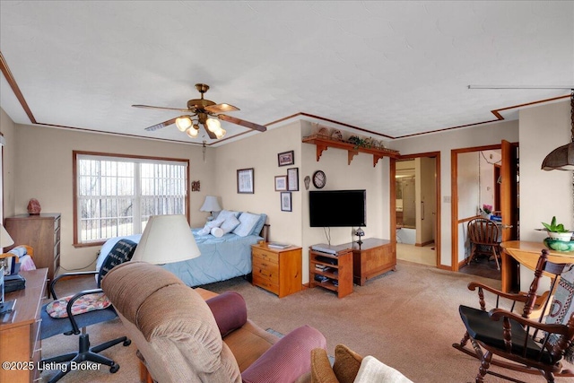 bedroom featuring carpet, ornamental molding, and a ceiling fan