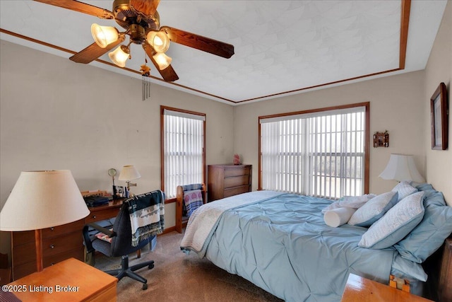 carpeted bedroom featuring crown molding and ceiling fan