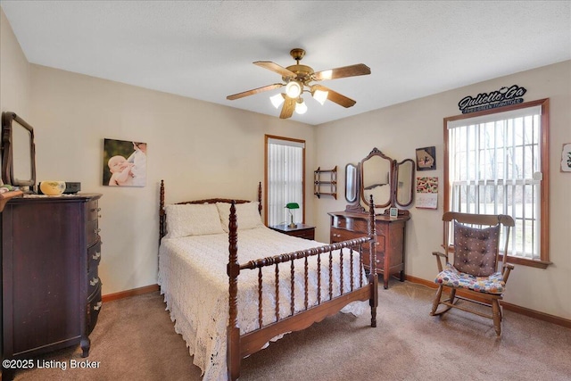 carpeted bedroom with ceiling fan and baseboards