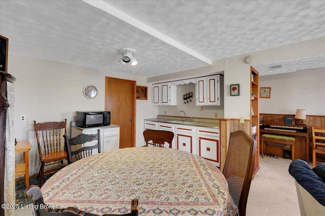 dining area featuring carpet floors and a textured ceiling