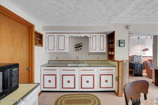 kitchen featuring open shelves, light carpet, a sink, a textured ceiling, and black microwave