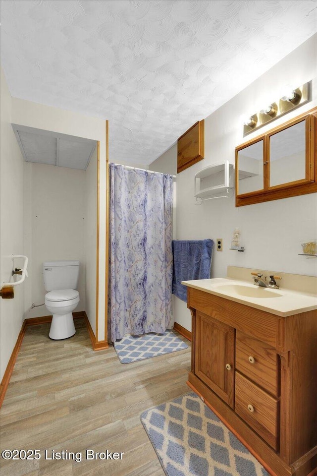 full bathroom with toilet, vanity, wood finished floors, a shower with curtain, and baseboards