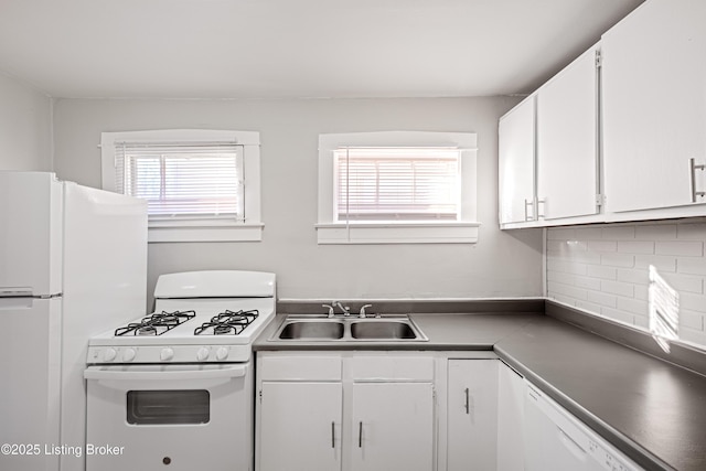 kitchen with white appliances, white cabinets, a sink, and decorative backsplash