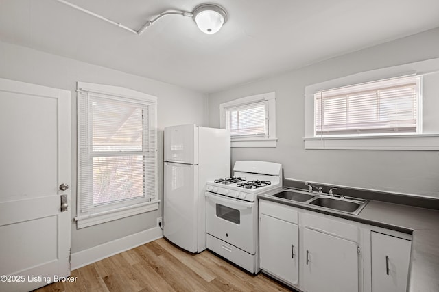 kitchen with light wood-style flooring, white appliances, a sink, white cabinetry, and baseboards