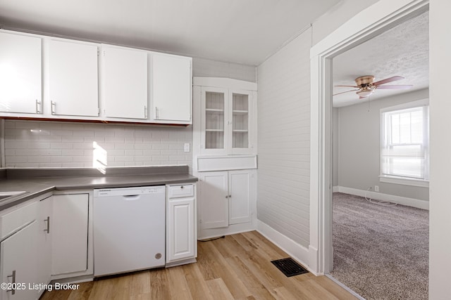 kitchen featuring visible vents, light wood-style flooring, white cabinets, ceiling fan, and dishwasher