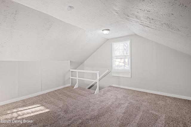 bonus room with lofted ceiling, carpet flooring, a textured ceiling, and baseboards