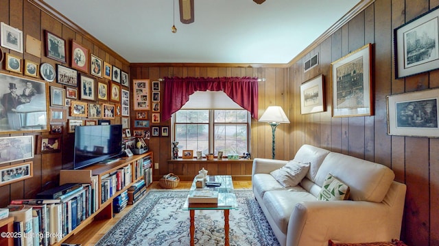 sitting room with wood finished floors, visible vents, crown molding, and ceiling fan