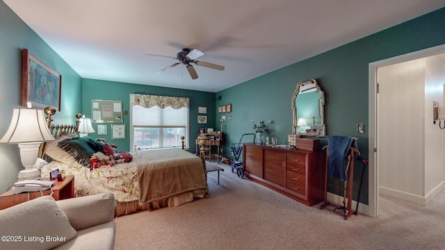 carpeted bedroom with ceiling fan and baseboards