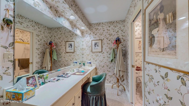 full bathroom featuring wallpapered walls, baseboards, and vanity