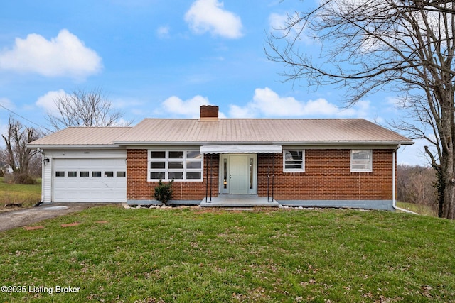 ranch-style house featuring brick siding, a chimney, an attached garage, a front yard, and driveway