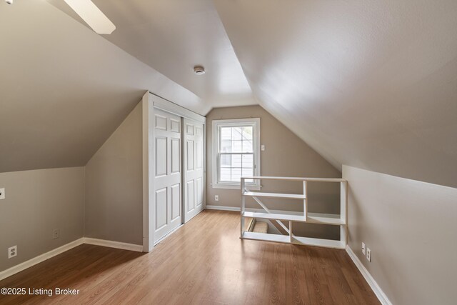 additional living space featuring lofted ceiling, baseboards, and wood finished floors