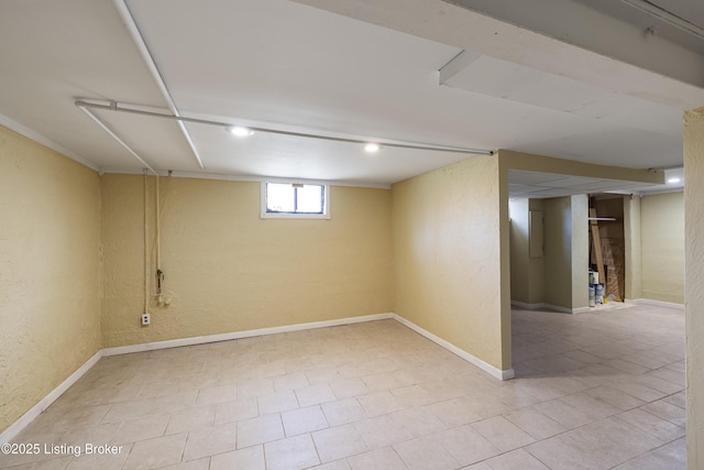 below grade area featuring baseboards and a textured wall