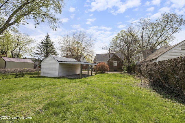 view of yard featuring a carport and an outbuilding