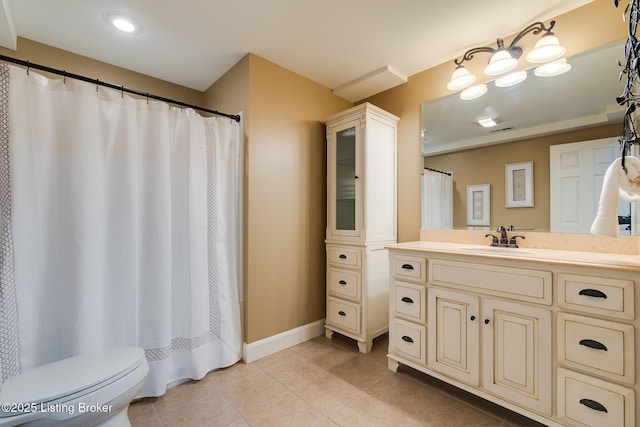 bathroom featuring tile patterned flooring, baseboards, vanity, and toilet