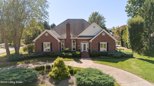 view of front of house featuring brick siding, a chimney, and a front yard