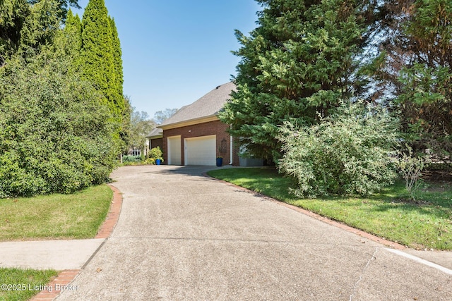 view of front of property with concrete driveway, brick siding, an attached garage, and a front lawn