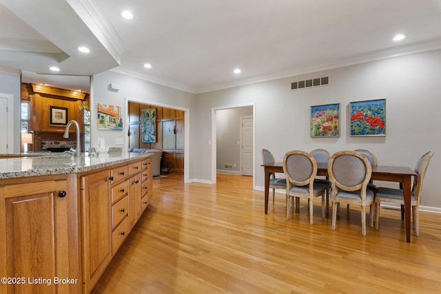 kitchen with recessed lighting, visible vents, light wood-style flooring, a brick fireplace, and light stone countertops