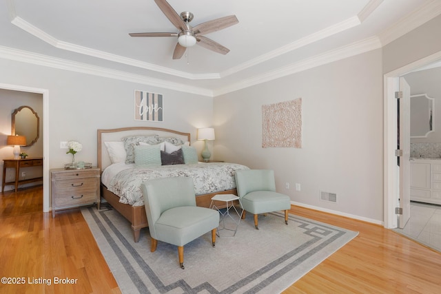 bedroom featuring ornamental molding, wood finished floors, visible vents, and baseboards