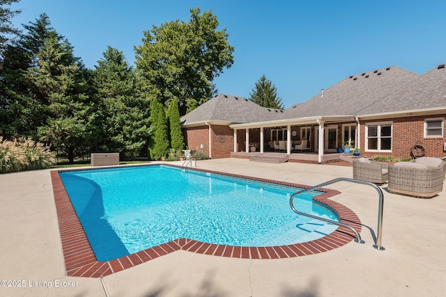 outdoor pool featuring a sunroom, a patio, and an outdoor living space